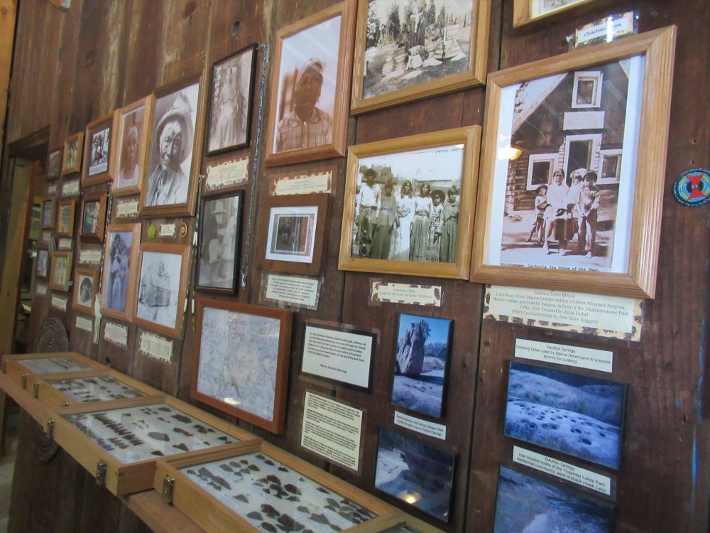 Displayed on a wall is a collage of old photographs of the Chukchansit people and their homes near Coarsegold 