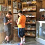 Photo of two young boys choosing rocks to buy. 