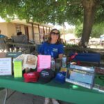 Photo of a volunteer who is selling merchandise at the Music in the Meadow event.
